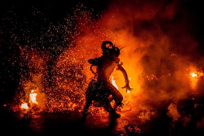 Silhouette people with fire crackers at night