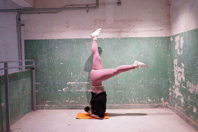 Full length of woman dancing on wall