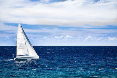 Sailboat sailing on sea against sky