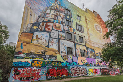 Low angle view of graffiti on building against sky