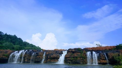 Scenic view of waterfall against sky