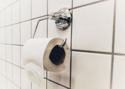 Close-up of toilet paper hanging on metal in toilet