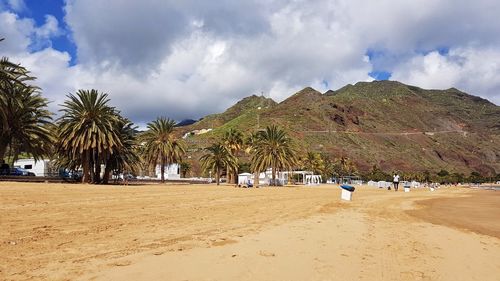 Panoramic view of people on beach against sky