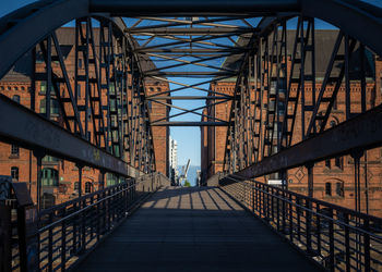 Low angle view of footbridge against bridge in city