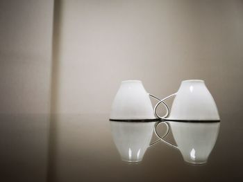 Close-up of illuminated lamp on table against wall at home