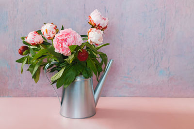 Flower vase on table against wall