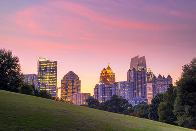 Buildings in city against sky during sunset