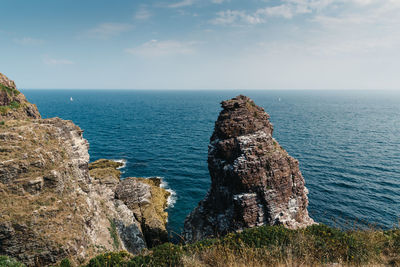 Scenic view of rocks in sea against sky