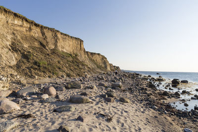 Rocks on beach against clear sky