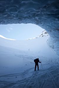 Silhouette person skiing in ice cave