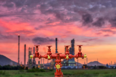 Close-up of cross on field against sky during sunset