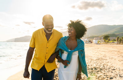 Portrait of smiling couple standing at beach