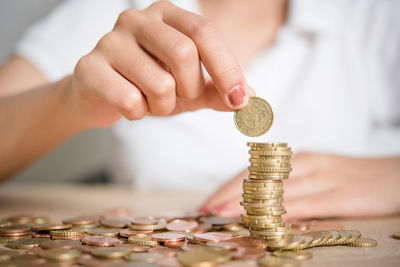 Midsection of businesswoman stacking coins on table