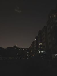 Low angle view of illuminated buildings against sky at night