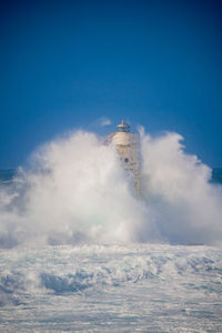 Low angle view of sea against blue sky