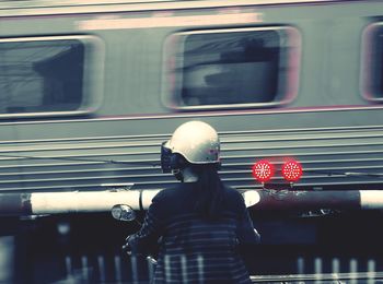 Rear view of man standing by train