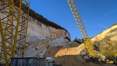 Low angle view of crane against blue sky