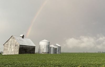 Scenic view of field against rainbow in sky