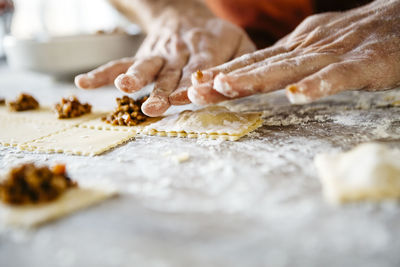 Cropped hands of man preparing food on table in kitchen