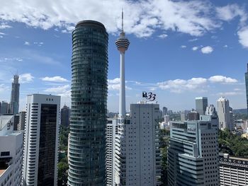 Modern buildings in city against cloudy sky