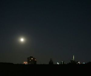 Low angle view of silhouette buildings against sky at night