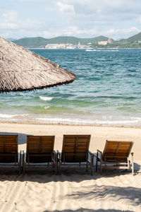 Beach umbrellas and chairs against blue ocean.