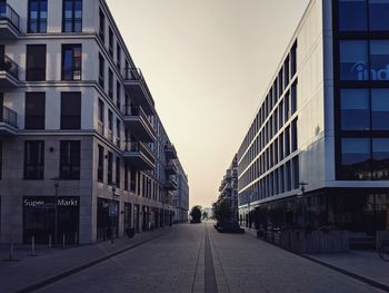 Street amidst buildings against clear sky