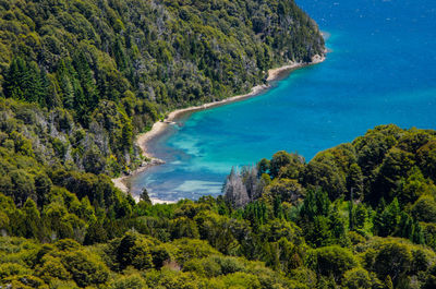 Scenic view of sea and mountains against blue sky