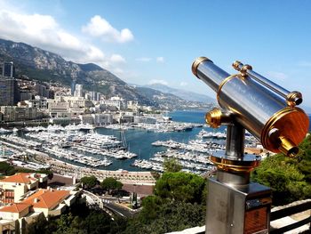 Coin-operated binoculars in city against sky