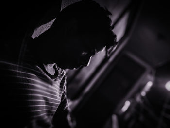 Side view of depressed man sitting in darkroom