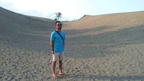 Full length of man standing on sand at beach