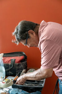 Latino man looking for tools in his toolbox, hispanic, with screwdriver in hand