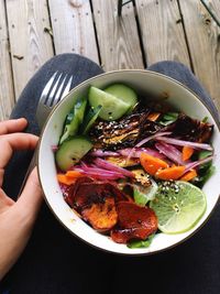 High angle view of woman holding salad in bowl