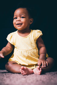 Cute baby girl sitting on sofa