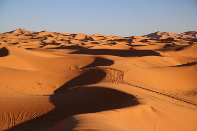 Sand dune in desert against clear sky