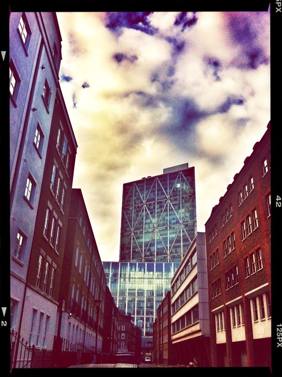 LOW ANGLE VIEW OF MODERN BUILDINGS AGAINST CLOUDY SKY