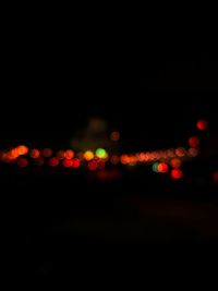 Defocused image of illuminated lights in city at night