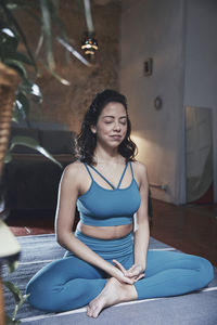 Woman meditating while sitting at home