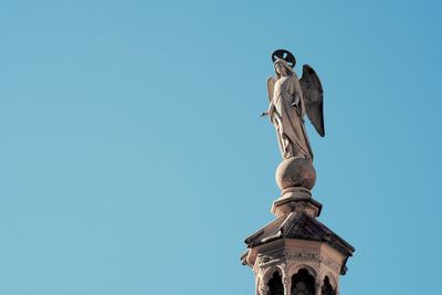 Low angle view of statue against blue sky