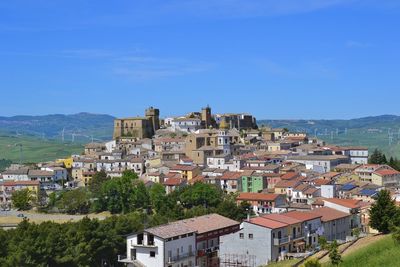 Buildings in city against clear blue sky