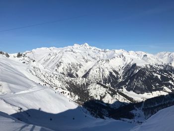 Scenic view of snowcapped mountains against clear blue sky