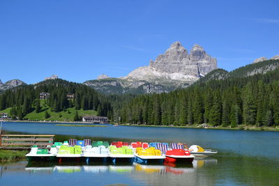 Scenic view of lake and mountains against clear blue sky