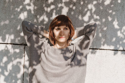 Portrait of a girl standing against wall