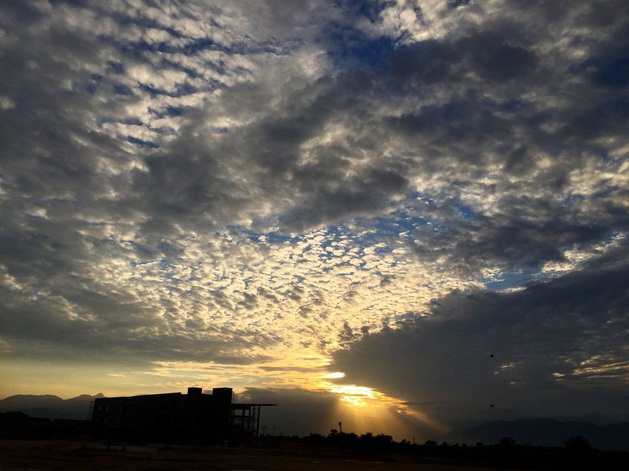 sunset, sky, architecture, low angle view, cloud - sky, building exterior, cloudy, scenics, nature, outdoors, beauty in nature, sunbeam, outline, majestic, tranquility, tranquil scene, no people, atmospheric mood, dramatic sky, cloudscape