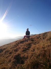 Silhouette of woman standing on field against sky