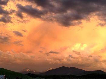 Scenic view of silhouette mountains against dramatic sky