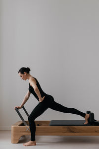 Full length of woman exercising in gym