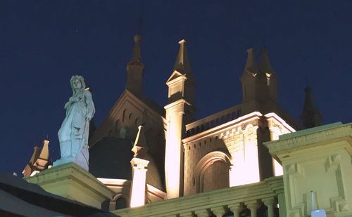Low angle view of statues at night