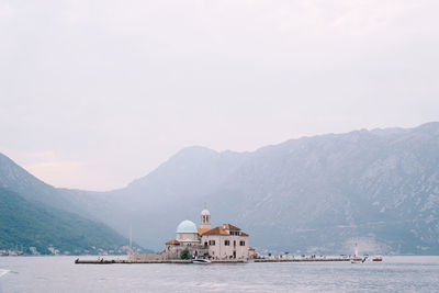 Scenic view of sea and buildings against mountains