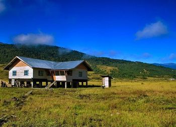 Scenic view of house on grassy field